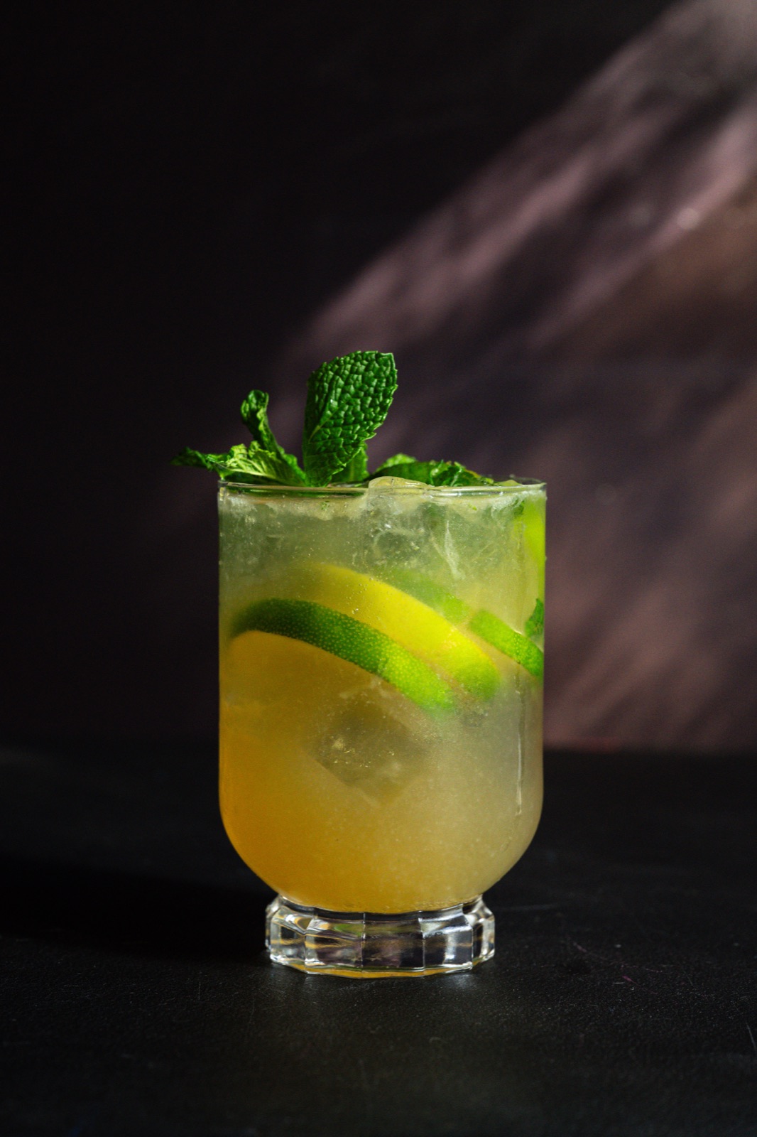 A tall citrus and mint highball over ice