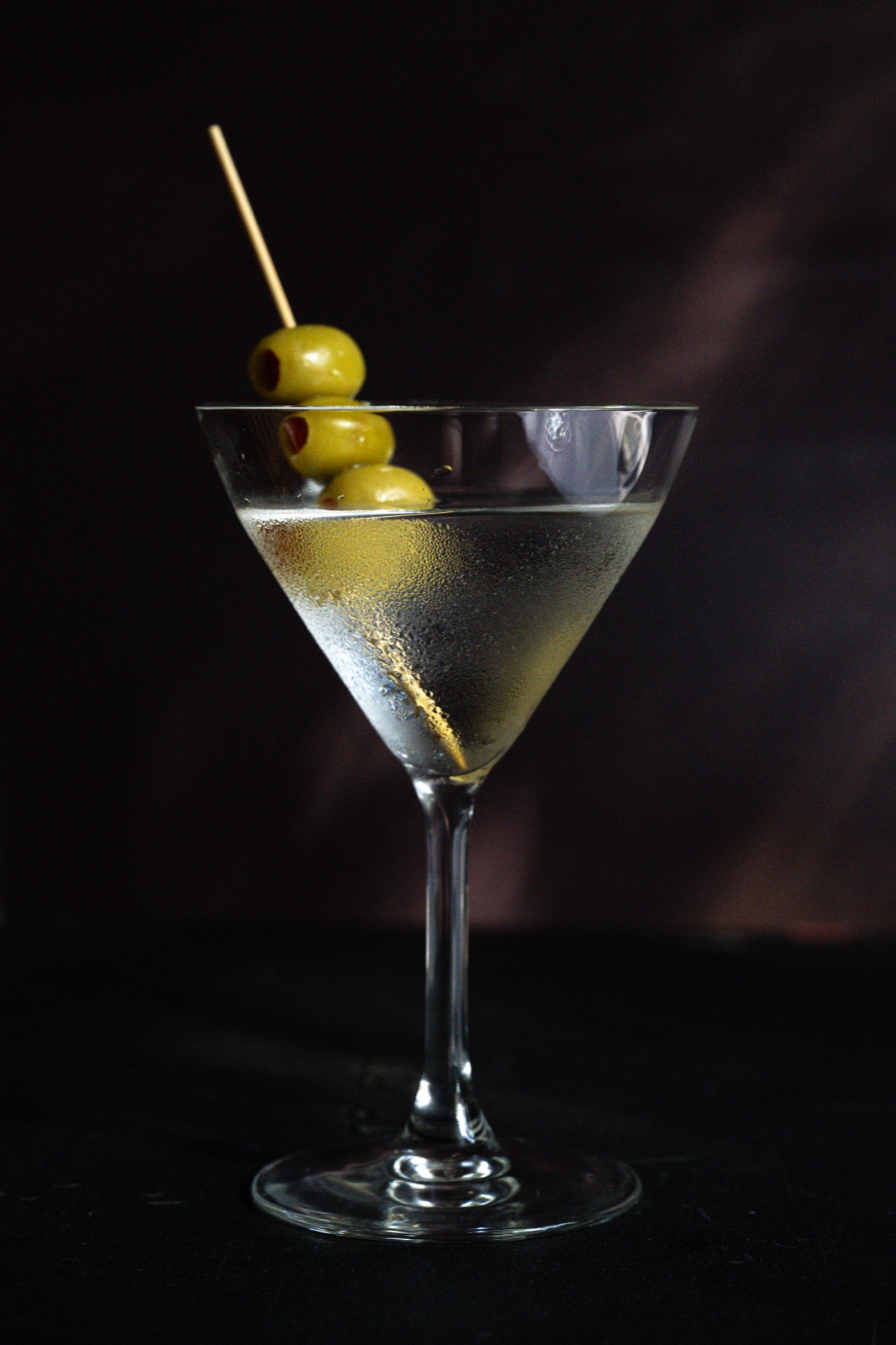 A classic martini garnished with three olives