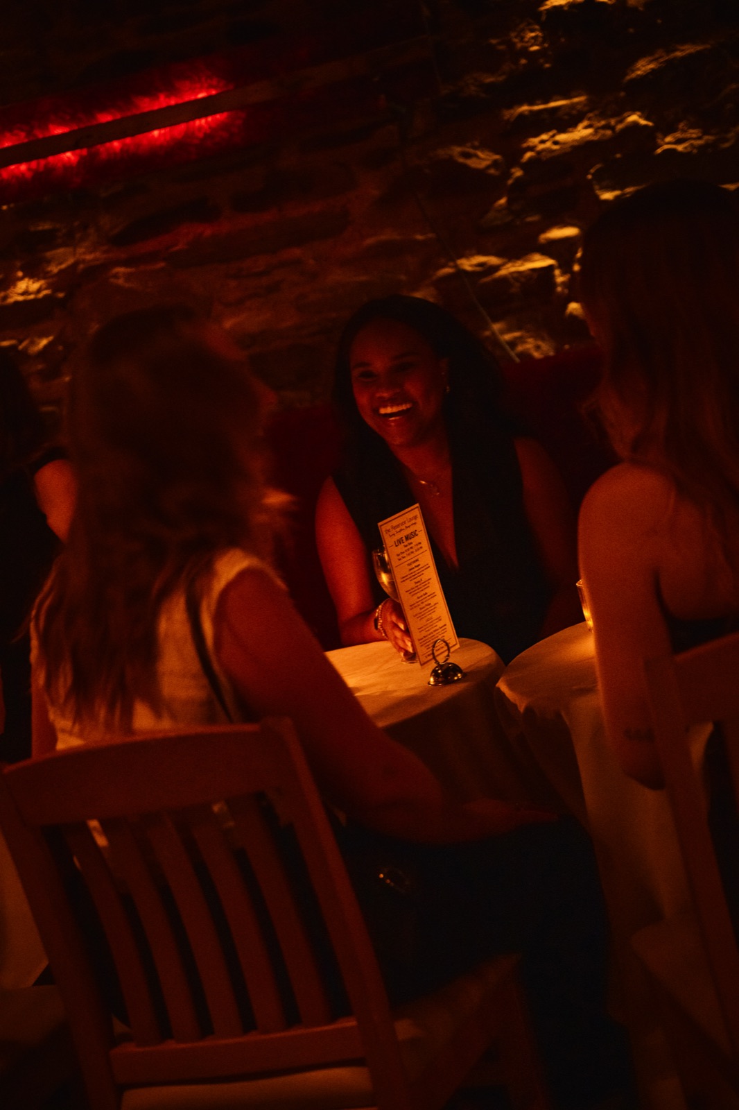 A guest laughing over a menu by candlelight